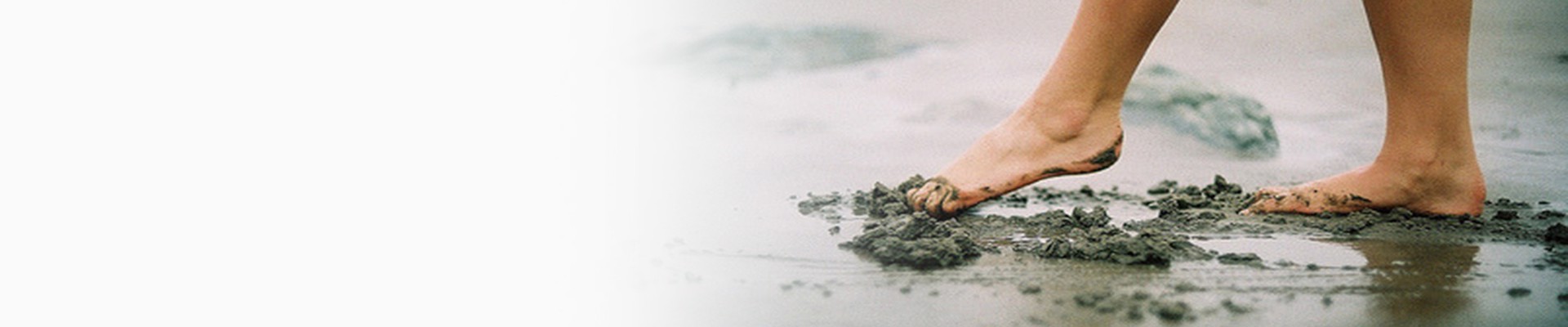 Feet in wet beach sand